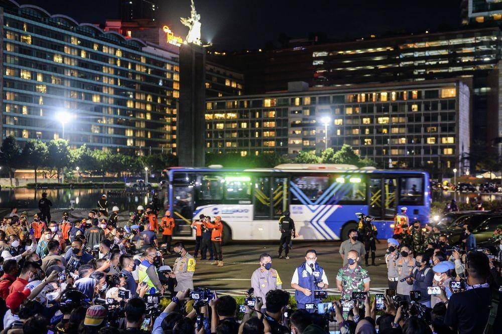 Gubernur DKI Jakarta Anies Baswedan (tengah) didampingi Kapolda Metro Jaya Irjen Pol Mohammad Fadil Imran (kiri) dan Pangdam Jaya Mayjen TNI Mulyo Aji (kanan) memberi keterangan pers pada awak media saat pemberlakuan Crowd Free Night di Bundaran Hotel Indonesia, Jakarta, Sabtu (1/1/2022) (ANTARA FOTO/M Risyal Hidayat)