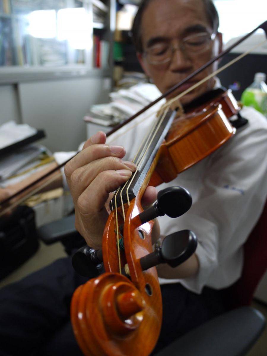 Shigeyoshi Osaki memainkan biola dengan senar jaring laba-laba. (japantimes.co.jp)