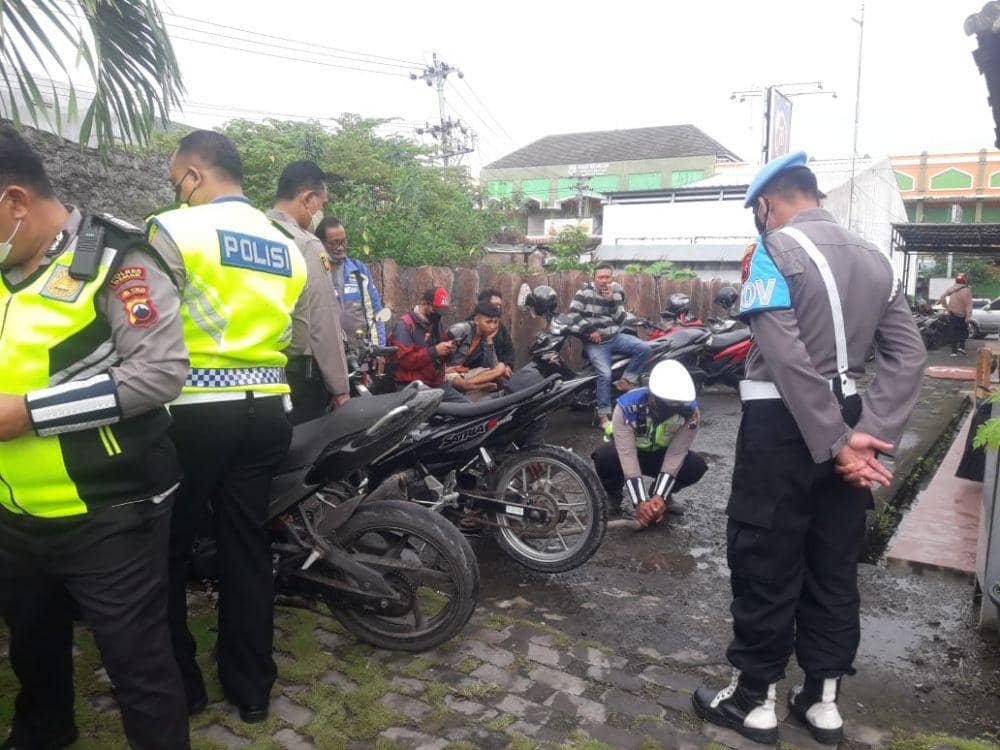 Seorang personel PM mengecek motor yang dipasangi knalpot brong di Semarang. (Dok Humas Polda Jateng)