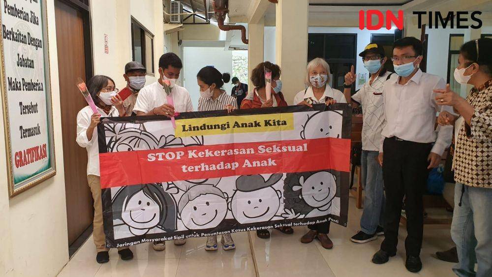 Sejumlah orang membentangkan spanduk dukungan pencegahan kekerasan seksual terhadap anak di Pengadilan Negeri Depok. (IDNTimes/Dicky)