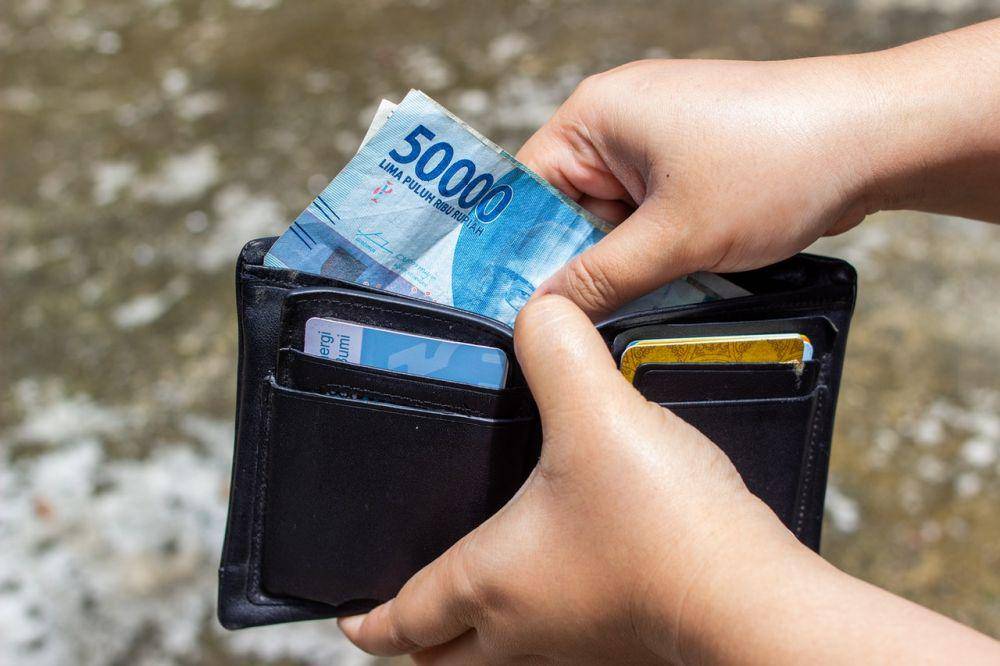 Ilustrasi mengeluarkan uang dari dompet. (Pexels.com/Ahsanjaya)