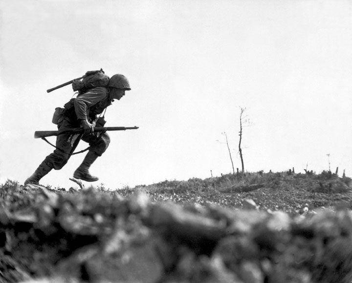 di Okinawa, seorang marinir berlari melintasi lapangan yang disebut Death Valley pada 10 Mei 1945 (dok. U.S. National Archives and Records Administration)