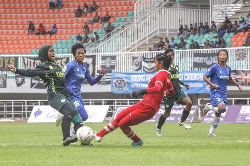 Pesepak bola Tira Persikabo Kartini Insyafada (kiri) berusaha menendang bola yang dihadang kiper Persib Bandung Putri Vivi Oktavia (kanan) dalam babak final leg ke-2 Liga 1 Putri 2019 di Stadion Pakansari, Cibinong, Bogor, Jawa Barat, Sabtu (28/12/2019). ANTARA FOTO/Yulius Satria Wijaya.