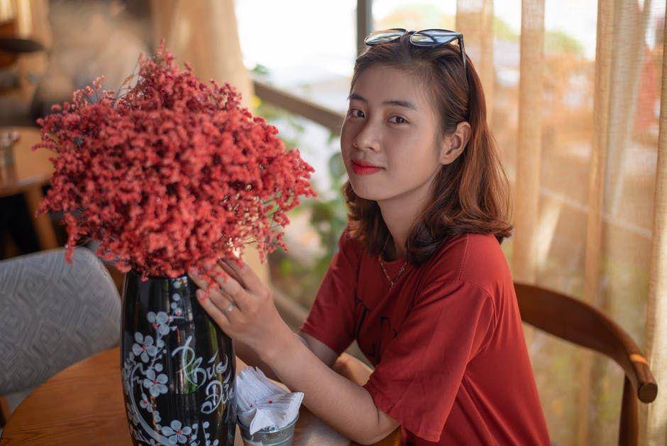ilustrasi seorang wanita memang vas bunga (Pexels.com/Đỗ Linh)