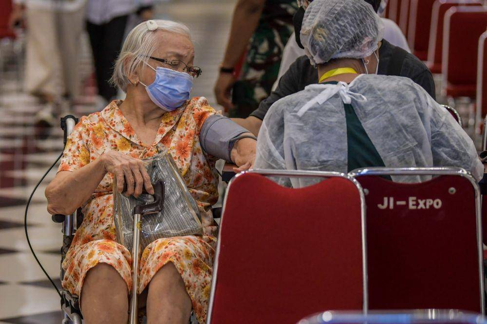 Petugas kesehatan memeriksa kesehatan warga calon penerima vaksin COVID-19 dosis ketiga saat vaksinasi booster COVID-19 di Jiexpo Kemayoran, Jakarta, Selasa (25/1/2022). (ANTARA FOTO/Galih Pradipta)