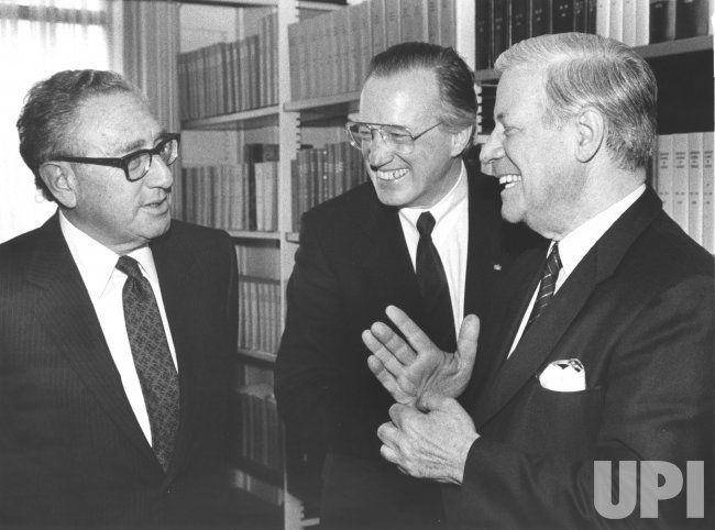 potret mantan Menteri Luar Negeri Henry Kissinger (kiri) mengobrol dengan mantan Kanselir Jerman Barat Helmut Schmidt (kanan) saat mereka menghadiri simposium di Universitas Georgetown pada 2 April 1987. Di tengah adalah Heinz Ruhnau, ketua Lufthansa Airlines. (dok. UPI Files/Vince Mannino)