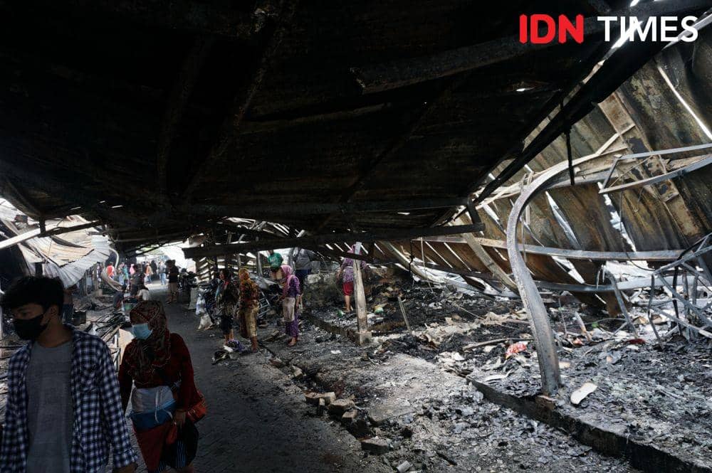 Para pedagang Relokasi Pasar Johar Semarang mengais puing-puing dagangan yang masih bisa diselamatkan pasca kebakaran yang terjadi pada Rabu (3/2/2022) malam. (IDN Times/Anggun Puspitoningrum)