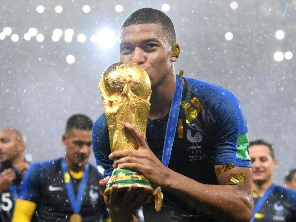 Kylan Mbappe mencium trofi Piala Dunia. (twitter.com/championsleague)