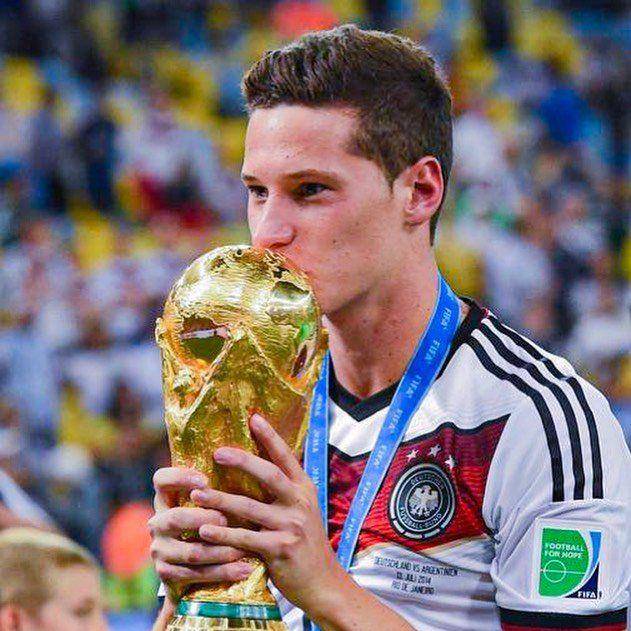 Julian Draxler mencium trofi Piala Dunia. (instagram.com/draxlerofficial)