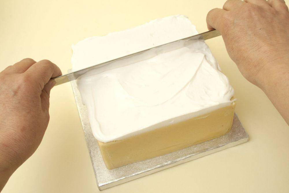 ilustrasi melapisi kue ulang tahun menggunakan butter cream. (caroldeaconcakes.com)