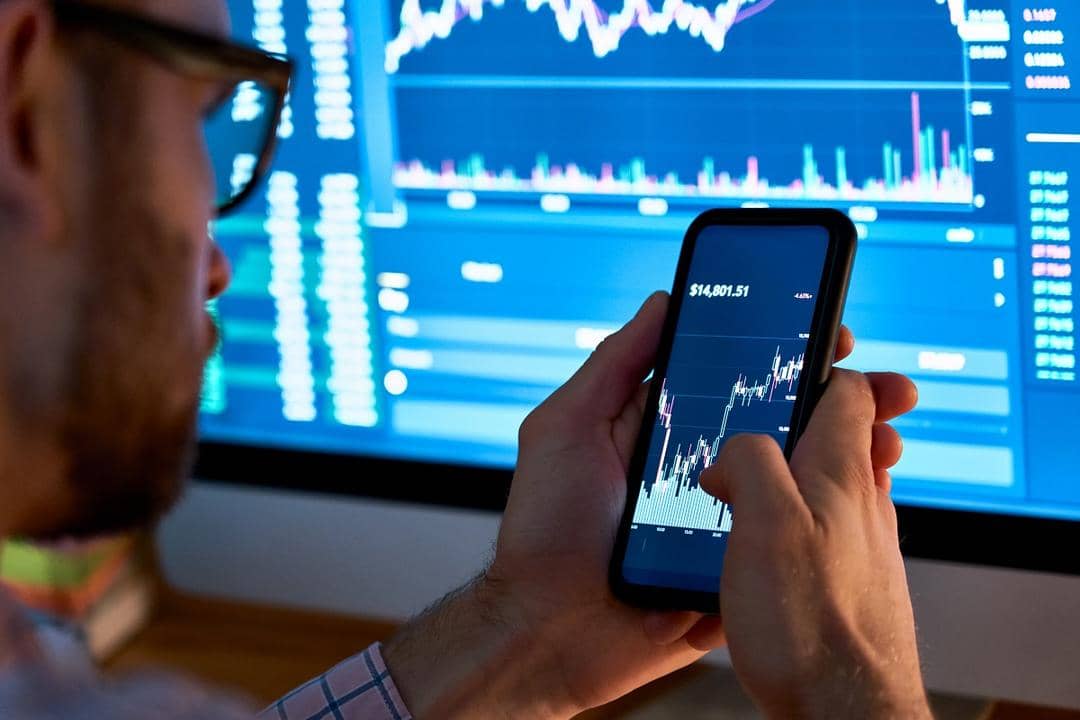 Ilustrasi Analis, investor, trader menggunakan analitik aplikasi ponsel untuk menganalisis pasar saham. Shutterstock/insta_photos