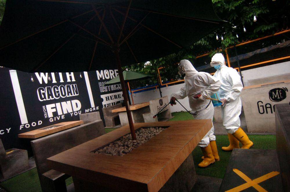 Petugas menyemprotkan cairan disinfektan saat penutupan sementara cafe Mie Gacoan di Tegal, Jawa Tengah, Kamis (10/2/2022). Penyemprotan disinfektan oleh BPBD tersebut akibat sebanyak sembilan karyawan dan lima pengunjung positif COVID-19 saat dilakukan tes usap antigen acak (ANTARA FOTO/Oky Lukmansyah)