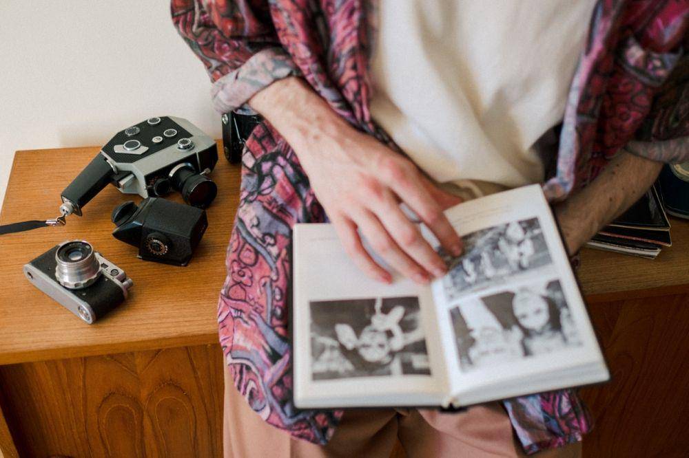Seorang pria sedang melihat album foto (Pexels.com/Ron Lach)