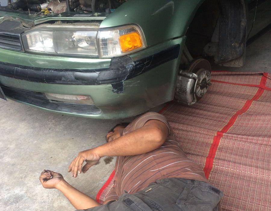 Mas Parman saat memperbaiki mobil pelanggannya. (Dok. Pribadi/Ari Budiadnyana)