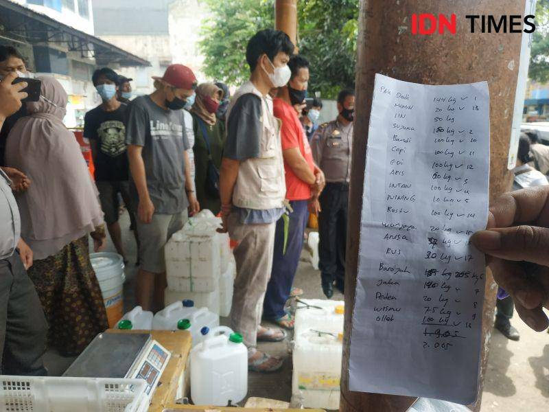 Pedagang mendaftarkan diri pada petugas sebelum membeli minyak goreng curah dari distributor. IDN Times/Debbie Sutrisno