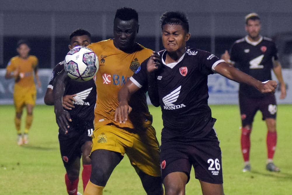 Pesepak bola Bhayangkara FC Ezechiel Ndouasel (kiri) berebut bola dengan pesepak bola PSM Makassar Ganjar Mukti (kanan) pada pertandingan Liga 1 di Stadion Kompyang Sujana, Denpasar, Bali, Jumat (25/2/2022) malam. (ANTARA FOTO/Nyoman Hendra Wibowo)