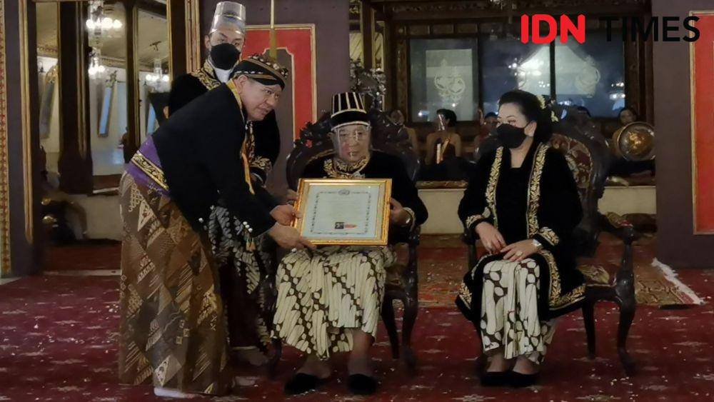 Pakoe Buwono (PB) XIII (tengah) memberikan kekancingan kepada Ketua DPD Ri, La Nyalla (kiri) saat upacara adat Tingalandalem Jumenengan di Keraton Solo, Minggu (27/2/2022). (IDN Times/Larasati Rey)