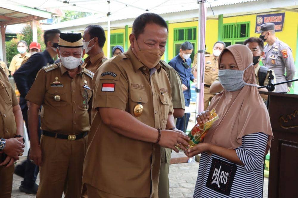 Gubernur Lampung Arinal Djunaidi simbolis menyerahkan minyak goreng ke warga operasi pasar di SDN 1 Taman Cari, Desa Taman Cari Kecamatan Purbolinggo Kabupaten Lampung Timur, Selasa (1/3/2022). (Dok. Pemprob Lampung).