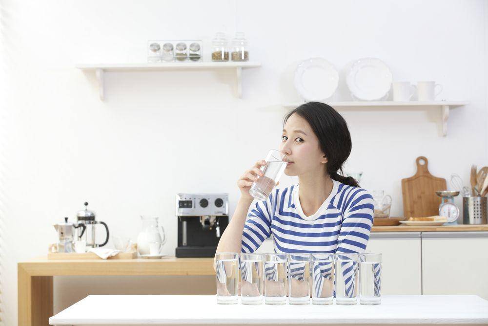 Seorang wanita sedang minum air putih (Shutterstock/JenJ Ivary)