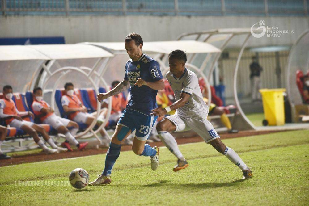 Pemain Persib, Marc Klok (kiri), tengah menjaga bola dari adangan pemain Arema pada duel pertama di putaran satu Liga 1 2021/22. (ligaindonesiabaru.com)