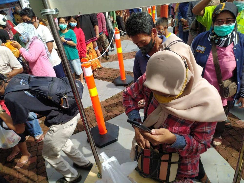 Warga mengantre di pasar sembako murah yang digelar di pelataran Monumen Mandala Makassar, Selasa (8/3/2022). IDN Times/Istimewa