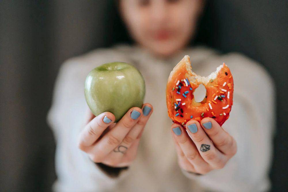 ilustrasi wanita memilih akan makan apel atau donat (pexels.com/Andres Ayrton)