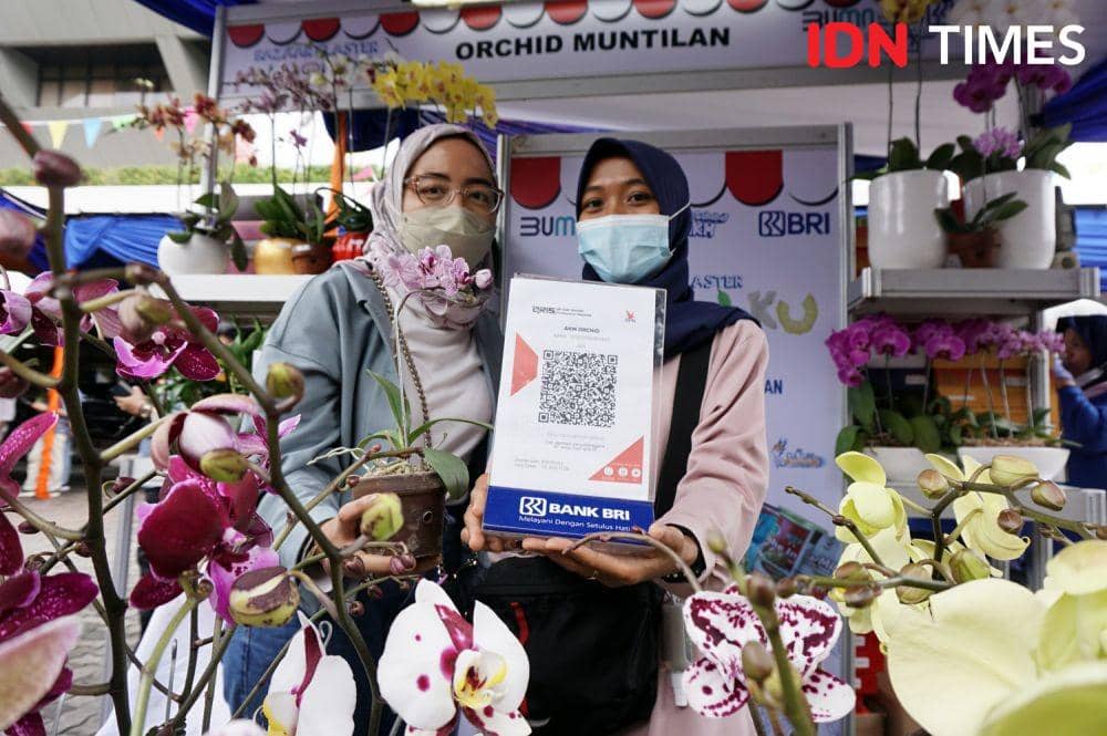 Pelaku UMKM Orchid Muntilan menunjukkan cara transaksi non tunai di Bazaar Klaster Mantriku di Halaman Gedung DPRD Provinsi Jawa Tengah, Kamis (10/3/2022). (IDN Times/Anggun Puspitoningrum)