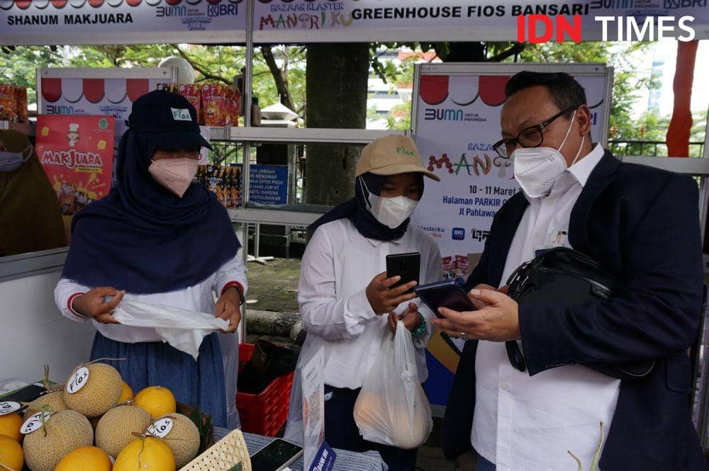 Regional CEO BRI Semarang, Wahyu Sulistiyono melakukan transaksi non tunai di salah satu stan UMKM di Bazaar Klaster Mantriku di Halaman Gedung DPRD Provinsi Jawa Tengah, Kamis (10/3/2022). (IDN Times/Anggun Puspitoningrum)