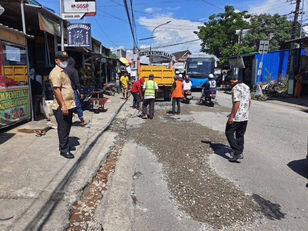 Petugas menimbun jalanan berlubang di ruas Jalan Antang Makassar, Jumat (11/3/2022). Humas Pemprov Sulsel
