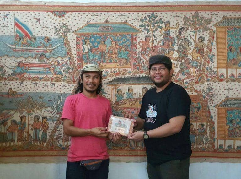 Louie Buana (kanan) dari Lontara Project saat menyerahkan lukisan La Salaga bergaya Kamasan serta buku dongeng "Legenda La Salaga" kepada aktivis literasi Ridwan Alimuddin di Polewali Mandar, Sulawesi Barat. (Dok. La Salaga Project)