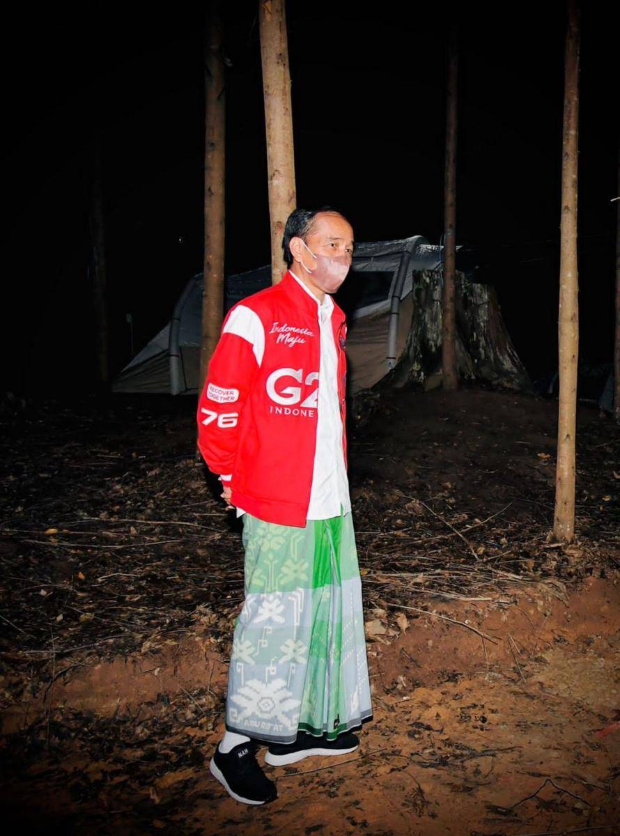 Presiden Joko "Jokowi" Widodo mengenakan jaket merah dan sarung berwarna hijau saat menghabiskan malam kemping di titik nol IKN Nusantara, Kalimantan Timur (Dokumentasi Biro Pers Istana)