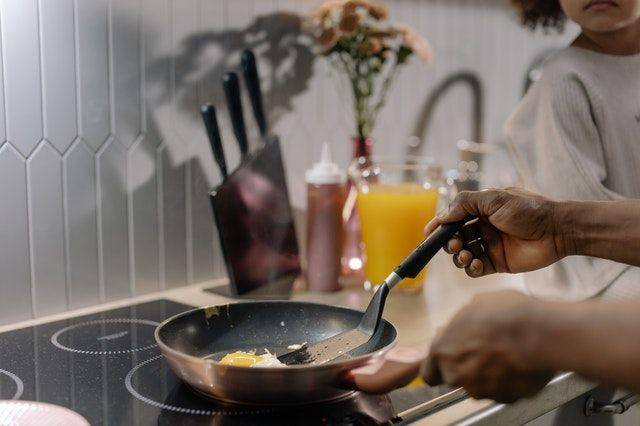 Orang tua yang sedang memasak telur bersama dengan anak. (pexels.com/cottonbro)