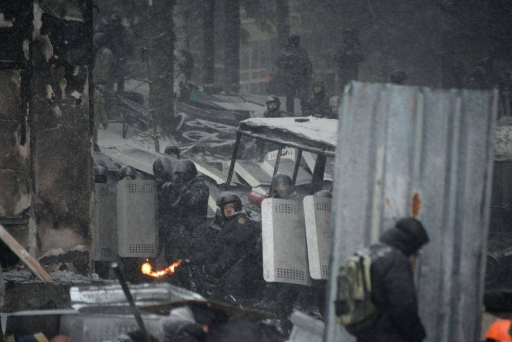 Pasukan polisi anti huru hara yang terdiri dari Pasukan Internal yang memegang posisi protektif dan polisi khusus Berkut yang menembak. Kiev, Ukraina. 22 Januari 2014 (Mstyslav Chernov/Unframe, CC BY-SA 3.0, via Wikimedia Commons)