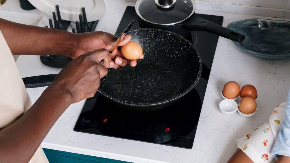 ilustrasi orang memasak telur dengan menggunakan kompor induksi (pexels.com/cottonbro)