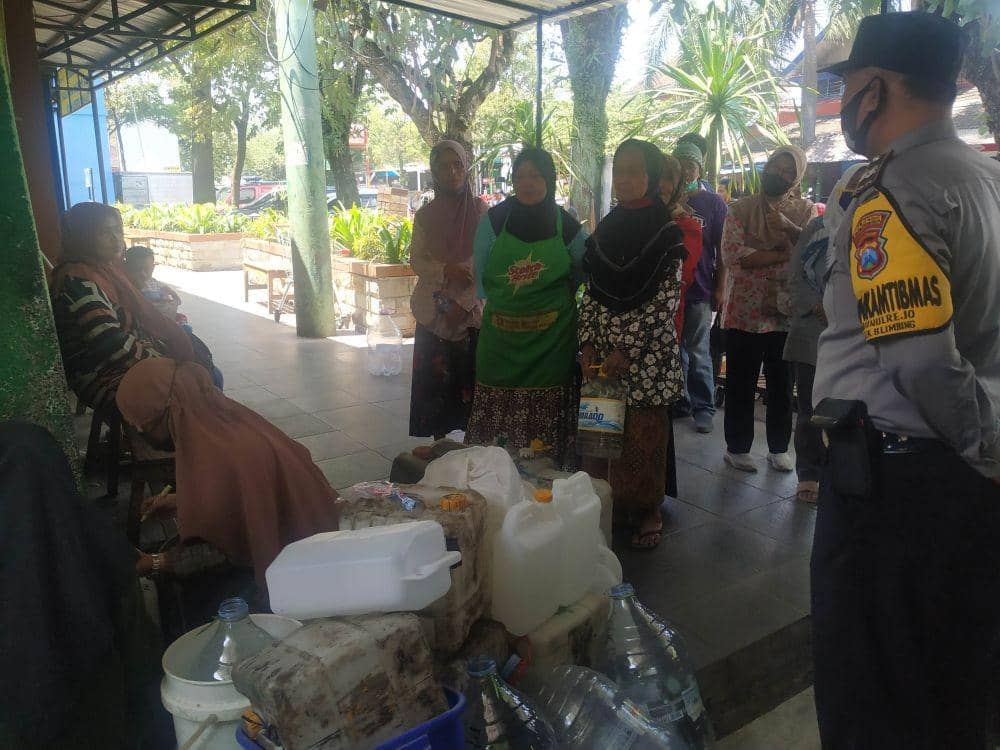 Para warga dan pedagang pasar mengantre untuk mendapat giliran jatah minyak goreng curah. IDN Times/Alfi Ramadana