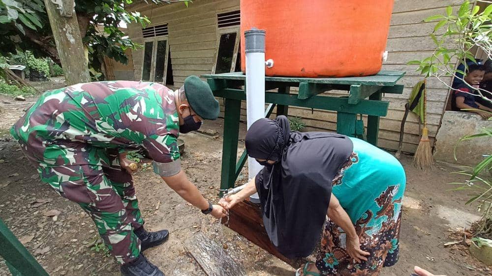 Prajurit Raider 600 Modang memberikan bantuan air bersih kepada warga Modang. Foto istimewa