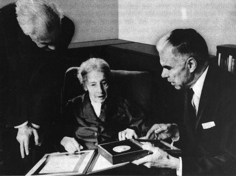 Lise Meitner menerima Enrico Fermi bersama dengan Hahn dan Strassmann. Dr. Glenn Seaborg mempersembahkan penghargaannya bersama Otto Frisch yang ada di sebelah kiri. (commons.wikimedia.org/IAEA Imagebank)