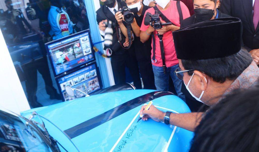 Rano Karno saat menandatangani replika oplet si Doel di Museum Motor Klasik SMK NMC. IDN Times/Alfi Ramadana