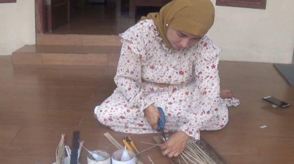 Ida Masfhiah sedang membuat kerajinan senin dari bahan pelepah pisang. IDN Times/Zainul Arifin