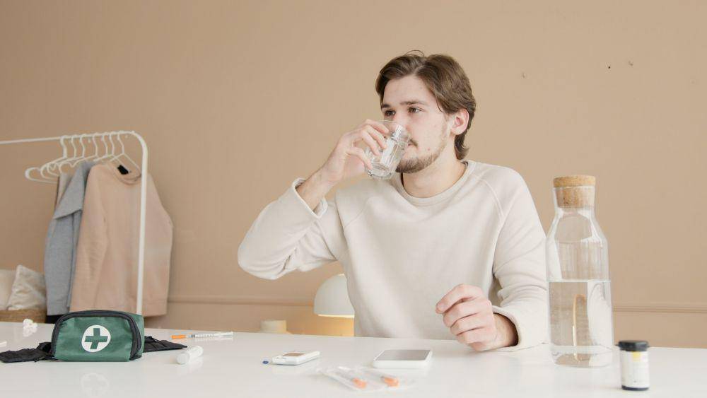 ilustrasi seseorang minum air mineral (pexels.com/Artem Podrez)