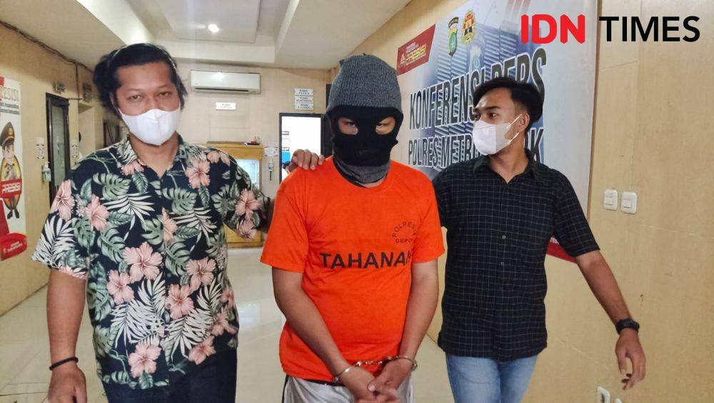 Tersangka kekerasan anak tiri dibawa kembali ke ruangan tahanan usai dilakukan pemeriksaan di unit PPA Polres Metro Depok. (IDNTimes/Dicky)