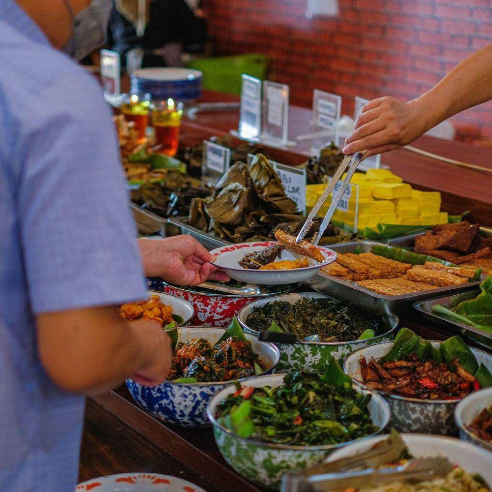 Makanan dalam sajian prasmanan dengan alat makan tradisional di Restoran Nasi Bancakan (instagram.com/nasibancakan.bdg)