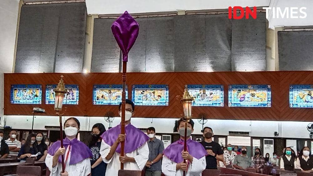 Sebuah tongkat salib yang ditutup kelambu diangkat sebagai simbol kenaikan Kristus Sang Juru Selamat. (IDN Times/Fariz Fardianto)