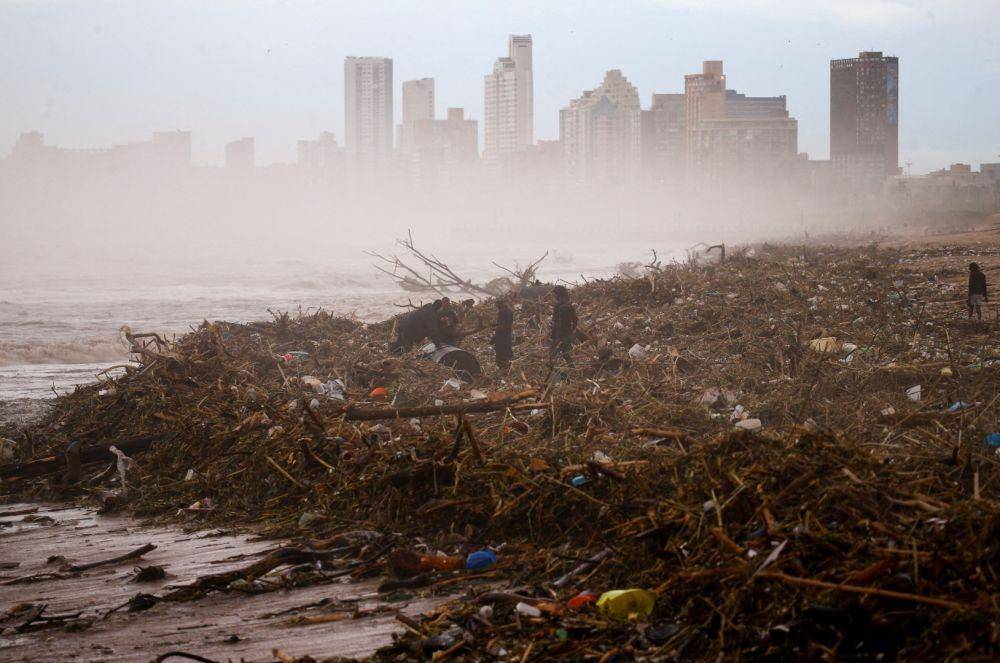 Warga mencari barang yang bisa mereka selamatkan di pantai setelah hujan lebat yang menyebabkan banjir, di Durban, Afrika Selatan, Selasa (12/4/2022). ANTARA FOTO/REUTERS/Rogan Ward/rwa/cfo