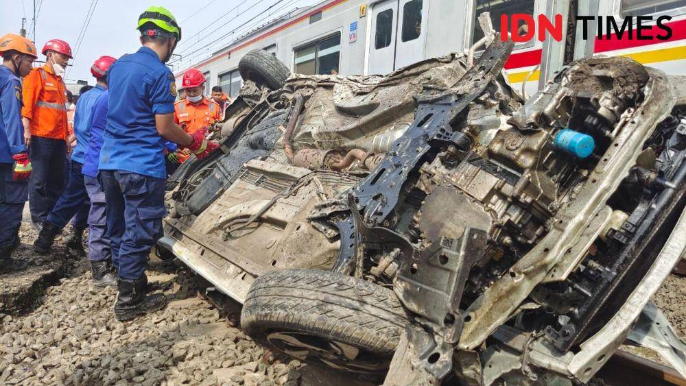 Anggota DPKP Kota Depok saat melakukan evakuasi minibus di palang pintu manual Rawageni, Kecamatan Cipayung, Kota Depok. (IDNTimes/Dicky)