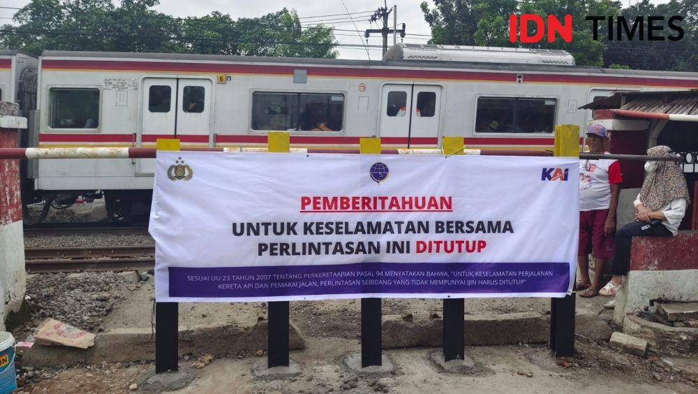 Spanduk pemberitahuan penutupan perlintasan palang pintu manual Rawa Geni, Kecamatan Cipayung, Kota Depok, telah di tutup PT KAI. (IDNTimes/Dicky)