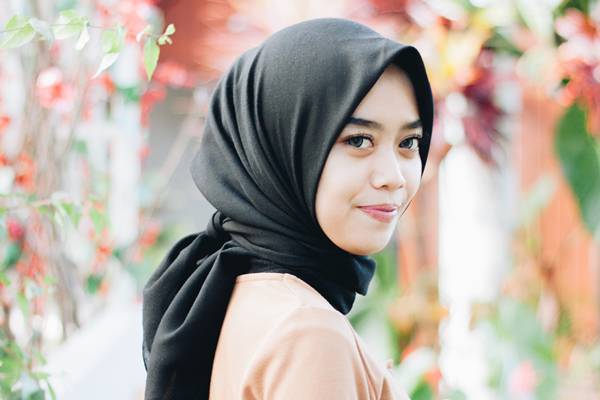 Hijab segi empat lilit belakang sebagai model hijab yang cocok untuk gamis (unsplash.com/mruqi)