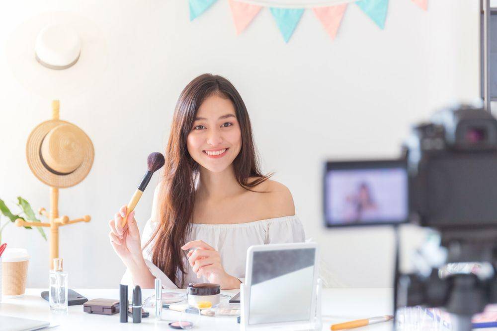 Seorang wanita sedang mengulas produk kecantikan (Shutterstock/BUNDITINAY)