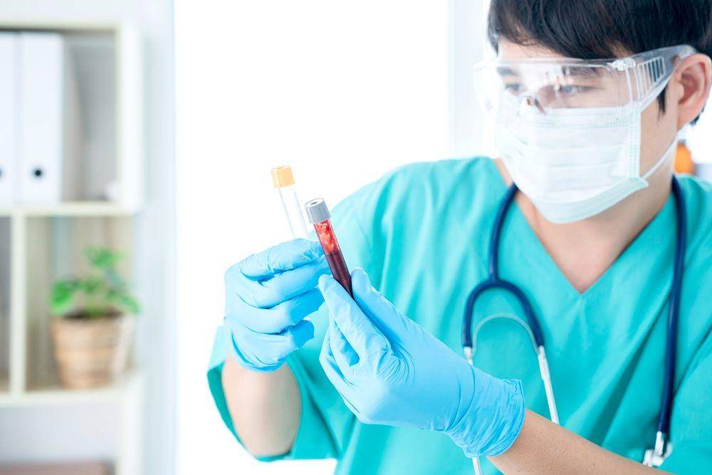 Seorang nakes sedang mengecek hasil sampel darah (Shutterstock/thirawatana phaisalratana)