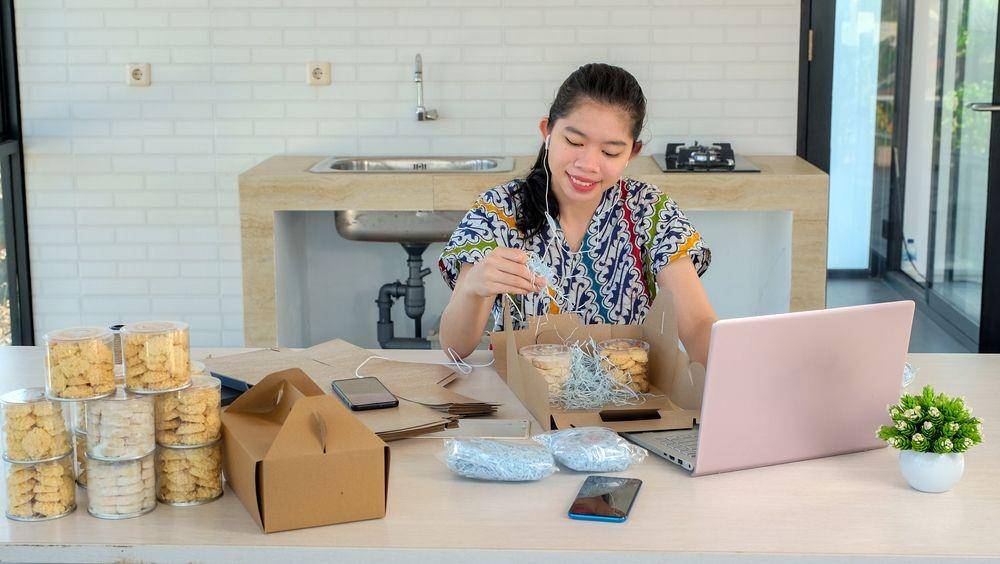 Seorang wanita sedang menyiapkan hampers (Shutterstock/Kristina Ismulyani)